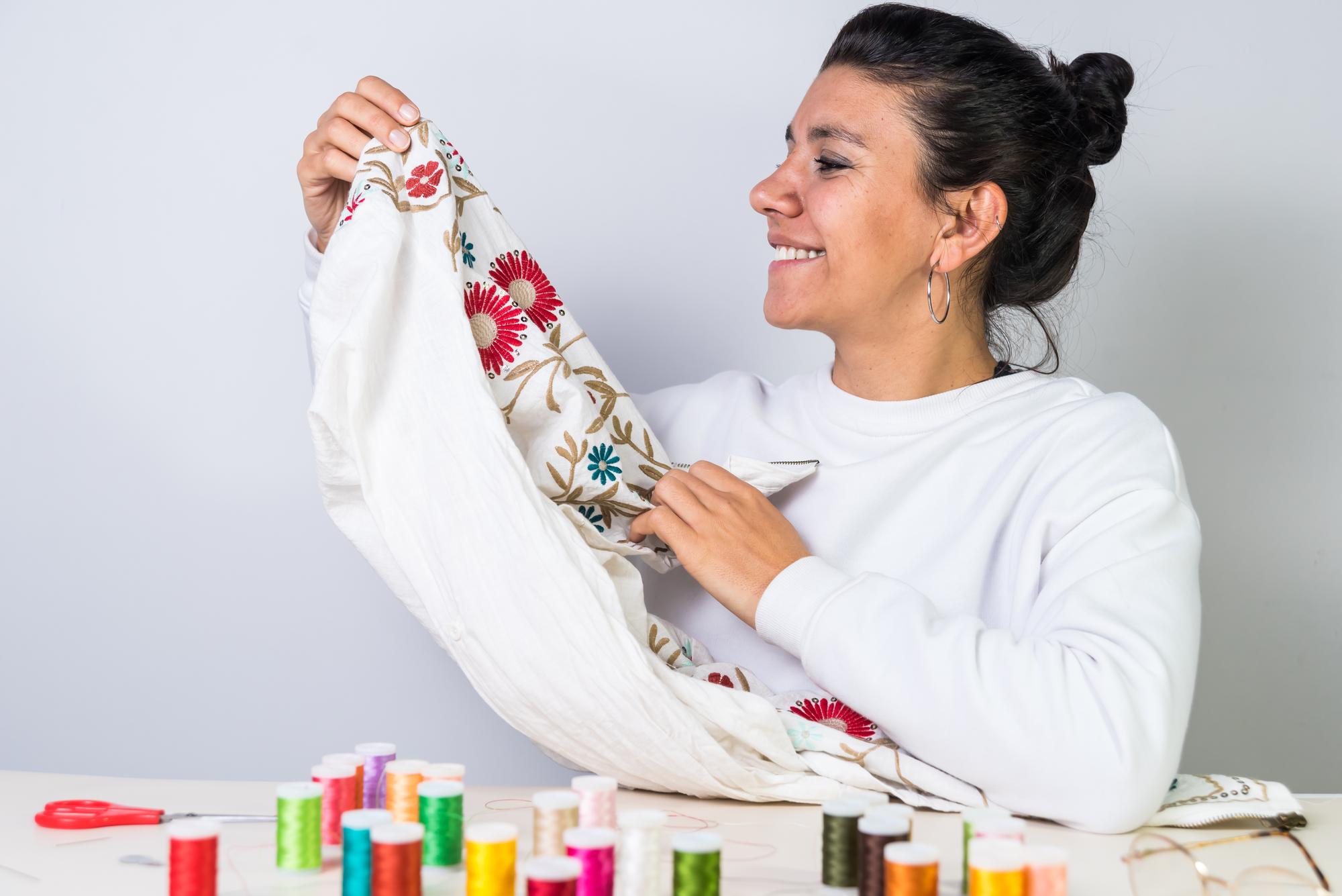 Artist stitching a floral motif in studio